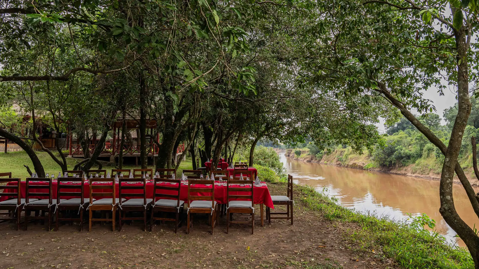 A long table laid for dinner on the bank of the Mara River