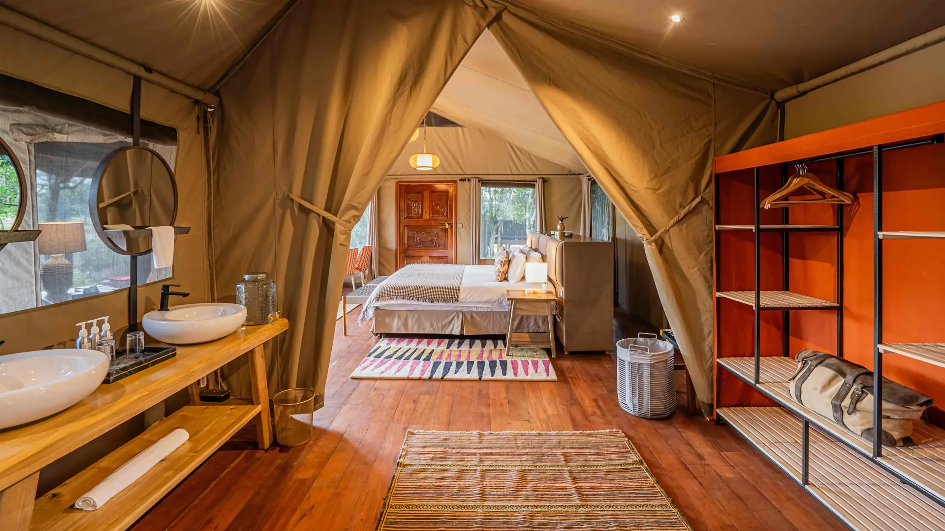 Inside a river suite, canvas rolled open onto the deck, twin basins and bed in view